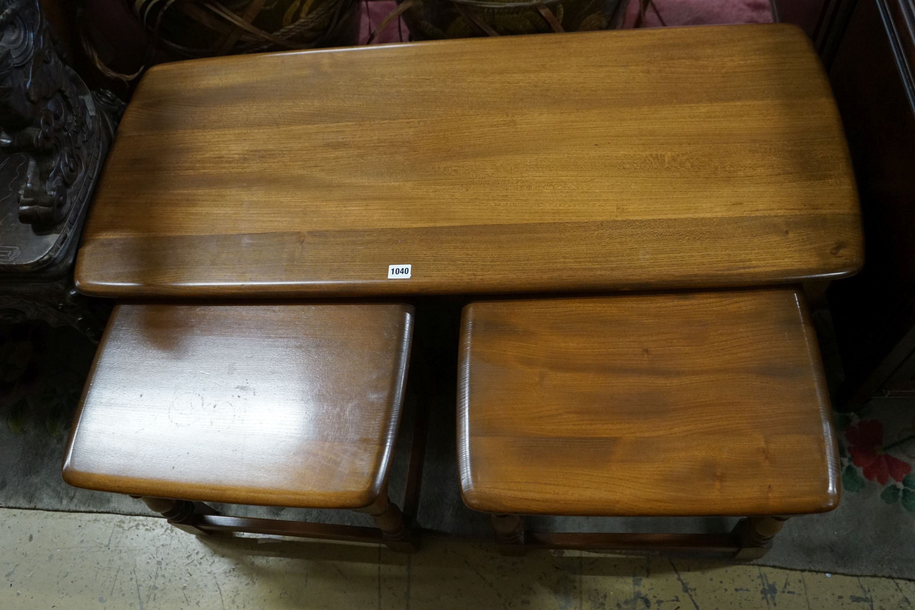 A nest of three Ercol elm tables, largest width 114cm, depth 49cm, height 41cm